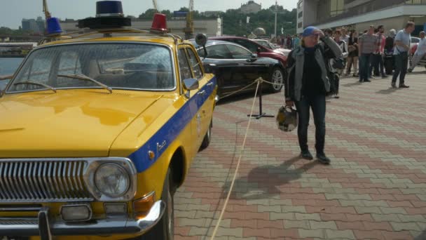 Odessa, ukraine - 11. juni 2016: bike cars und rock n roll retro festival. Menschen und Biker in der Nähe von Oldtimer-Polizeiauto. — Stockvideo