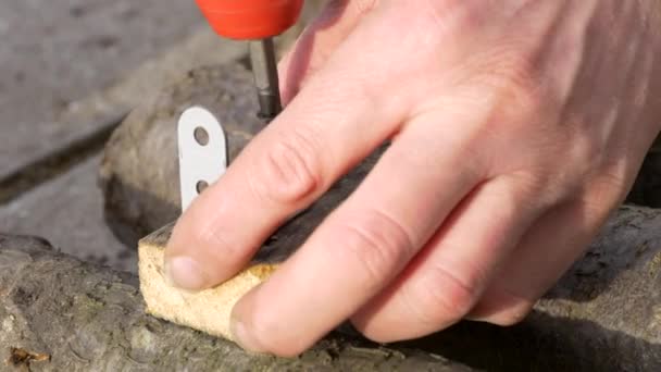 Metalen hoek plaat vastgeschroefd aan de houten balk door schroevendraaier. — Stockvideo