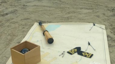 Navigasyon aletleri, grafik üzerinde kum. Granit kayalar. Metal iskele, baba