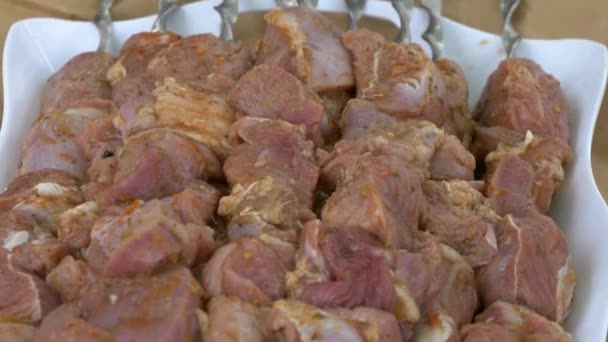 La carne cruda su spiedini l'acciaio inossidabile si trova su vassoio. Carne marinata per grigliate . — Video Stock