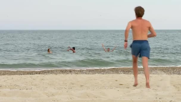 Homme courant et sautant dans l'eau avec une éclaboussure — Video