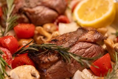 Limonlu, domatesli ve biberiyeli kızarmış kuzu eti.