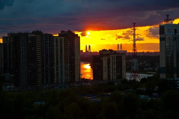 川のそばの住宅街の上の赤い夕日 — ストック写真