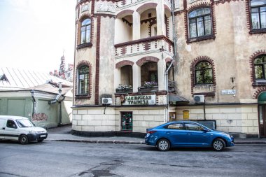 Taş döşeli bir caddede eski bir tuğla bina. 