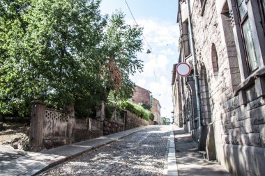 Taş döşeli bir caddede eski bir tuğla bina. 