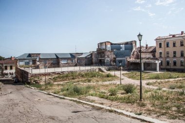 Taş döşeli bir caddede eski bir tuğla bina. 