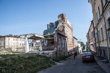 Taş döşeli bir caddede eski bir tuğla bina. 