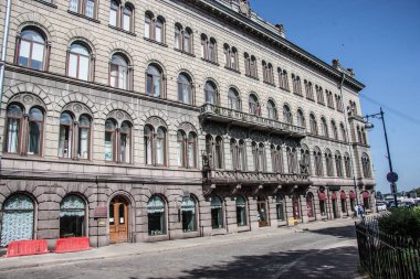 Taş döşeli bir caddede eski bir tuğla bina. 