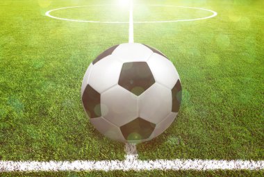 Futbol çim üzerinde top ve bir portakal güneş gibi ışık var.