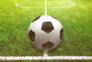 Futbol çim üzerinde top ve bir portakal güneş gibi ışık var.