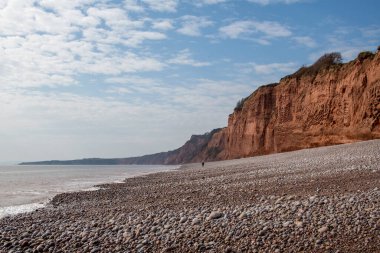 Yalnızlık ve yalnızlık, tek bir figürün muhteşem taşlı plajda tek başına yürüdüğünü gösteren konsept. Küçücük bir insanla yapılmış geniş bir görüntü, yalnızlık hissinin altını çizer. Ruh Sağlığı.