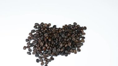 kavrulmuş kahve çekirdekleri ve beyaz tabakta ahşap tabaklar.