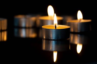 Siyah camdaki küçük mumlar.