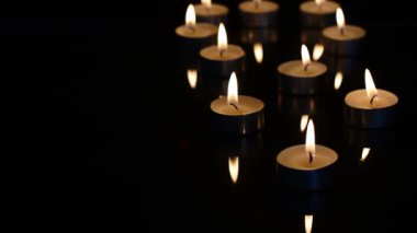 Siyah camdaki mumlar ve yansımalar