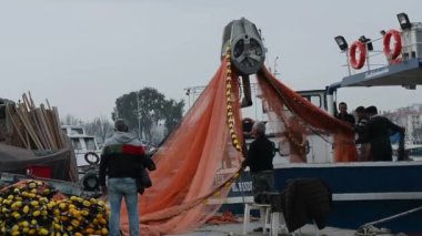 Türkiye, İzmir 10 Mart 2021 balıkçı teknesi limanda ağ topluyor