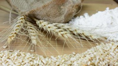 Tahıl taneleri, buğday taneleri, buğday taneleri, buğday kulakları, un ve ekmek dilimleri tahta masa kulaklarında, un ve ekmek dilimleri