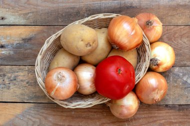 Tahta masada büyük lezzetli soğanlar ve patatesler.