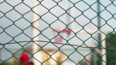 Açık Saha Spor Tesisi 'nde basketbol oynayan iki genç çocuk. Kablo Engelinin Arkasındaki Bulanık Resim