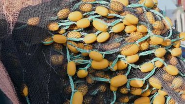 Harbor Sliding Shot 'ta balıkçı ağı şamandıraları, Liman balıkçı teknesi ve bir yığın sarı şamandıra. Pürüzsüz kayma hareketi, deniz detayları ve ticari balıkçılık ekipmanları.