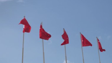 İzmir, Türkiye 16 Şubat 2025 Bayrak Direkleri üzerinde ağır çekimde dalgalanan Türk ulusal bayraklarının gerçek çekimi. Hakiki dış çekim, yapay zeka değil..