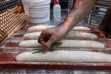 Beyaz fırıncı biraz ekmek kesiyor.