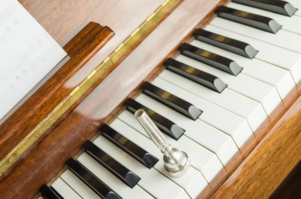 Trumpeta náustek na klávesy klavíru, zblízka — Stock fotografie
