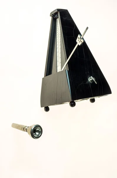 Metronom ve boş beyaz izole bir trompet ağızlık 