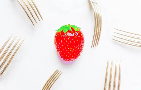 tek bir çilek üzerinde doymuş, goldenvintage çatal tarafından çevrili