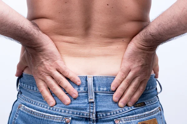 Bel bölgesinde şiddetli ağrı ile orta yaşlı adam onları onun acısını dindirmek için iter