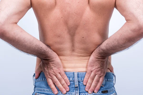 Bel bölgesinde şiddetli ağrı ile orta yaşlı adam onları onun acısını dindirmek için iter