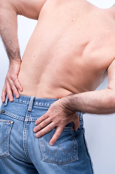 Bel bölgesinde şiddetli ağrı ile orta yaşlı adam onları onun acısını dindirmek için iter