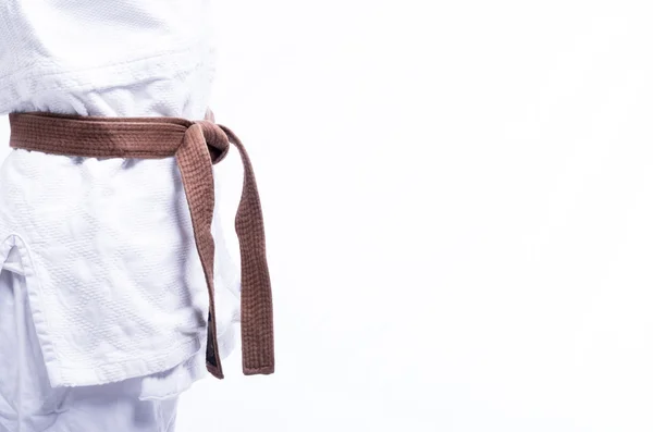 Zbliżenie na judo jednolite, judo-gi, brązowy pas na białym tle — Zdjęcie stockowe