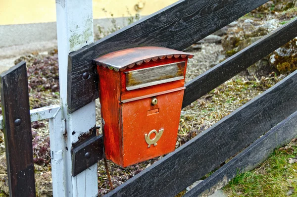 Old red mailbox on a wooden fence. Austria. — Stock Photo, Image