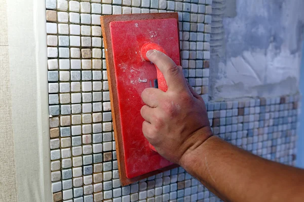 Repairs in the apartment: installing the mosaic tile on the wal — Stock Image Repairs in the apartment: installing the mosaic tile on the wal Stock Photo