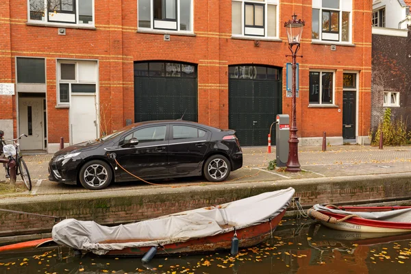 AMSTERDAM / NETHERLANDS - OKTOBER, 25, 2015. Încărcarea mașinii electrice pe digul canalului din Amsterdam, Olanda . — Fotografie, imagine de stoc