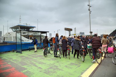 Amsterdam, Hollanda nehri geçip feribot için sıraya insanlar stand.
