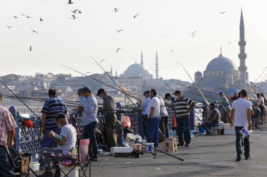 İSTANBUL, Turkey - 06 Ekim 2020. Arkasında Valide Sultan Camii olan Galata Köprüsü. Balıkçılar ve oltalar köprüde balık tutuyorlar. İstanbul, Türkiye.