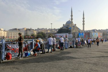 İSTANBUL, Turkey - 06 Ekim 2020. Arkasında Valide Sultan Camii olan Galata Köprüsü. Balıkçılar ve oltalar köprüde balık tutuyorlar. İstanbul, Türkiye.