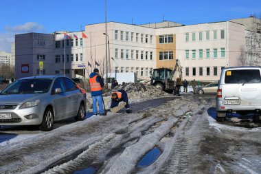 BALASHIKHA, RUSSIA - MARCH 19, 2021. Bumpy street in the residential area in front of the school N 27. Municipal service is clearing the street of ice. City of Balashikha, Moscow region, Russia.