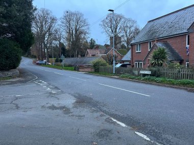 Thurcaston, Leicestershire, UK November 9th 2025 Quiet Urban Street With Brick Buildings, Sidewalk, and Green Hedge Near Residential Houses