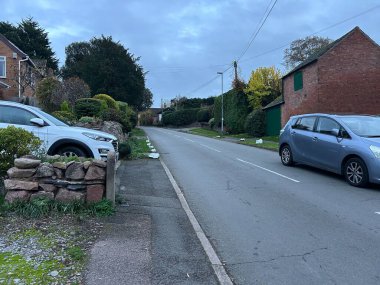 Thurcaston, Leicestershire, UK November 9th 2025 Quiet Urban Street With Brick Buildings, Sidewalk, and Green Hedge Near Residential Houses