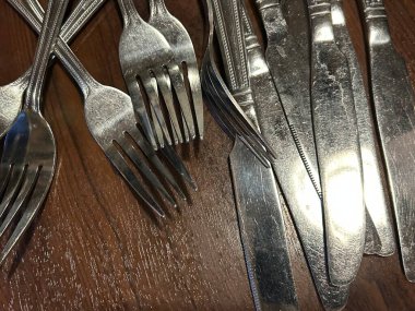 Dağınık Gümüşler Yığını: Ahşap Masadaki Çatallar ve Bıçaklar