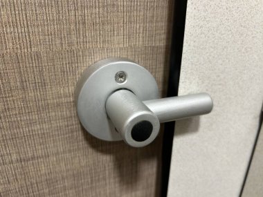 Tahta kapıdaki gümüş kapı kolunun yakın çekimi.