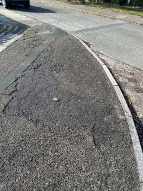 Kaldırımlı ve kaldırımlı çatlak asfalt yol kenarı