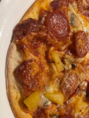 Erimiş peynirli taze fırınlanmış Pepperoni Ananas Mantarlı Pizza.