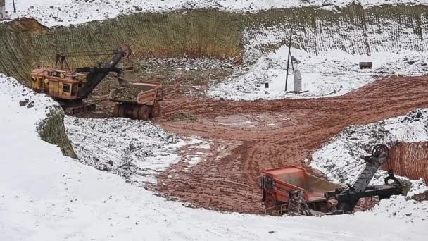 Екскаватор завантажує руду в сміттєвоз. Зима . — стокове відео