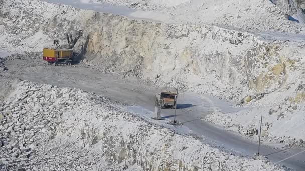 Excavator loads ore into dump-trucks. Pan. — Stock Video