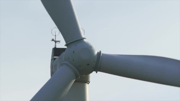 Motion the blades of a large wind turbine in a field against a background of orange sunset on the horizon with a beautiful hills. Alternative energy sources. Windy park. Ecological energy.Industrial — Stock Video