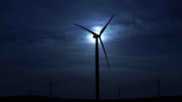 Ruch łopaty dużej turbiny wiatrowej w polu na tle niesamowitej nocy zachmurzone niebo i Księżyc. Alternatywne źródła energii. Park wiatrów. Energia ekologiczna.Przemysł — Wideo stockowe