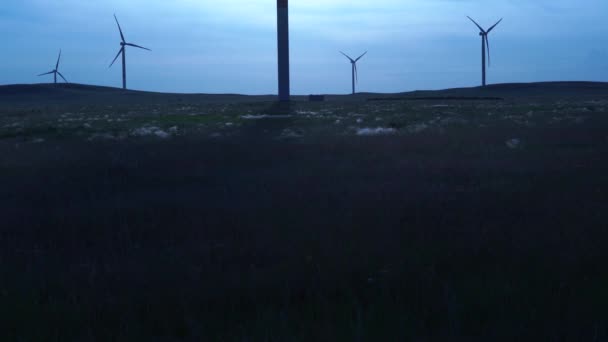 Blades of a large wind turbine in a field against a background of cloudy grey sky on the horizon with a beautiful hills. Alternative energy sources. Windy park. Ecological energy.Industrial — Stock Video